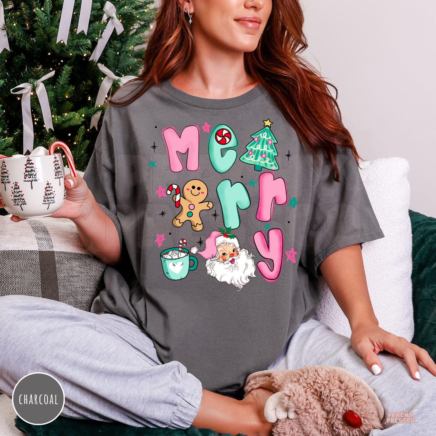 Model sitting on a couch wearing a charcoal gray oversized vintage Merry Christmas t-shirt paired with grey loungewear.