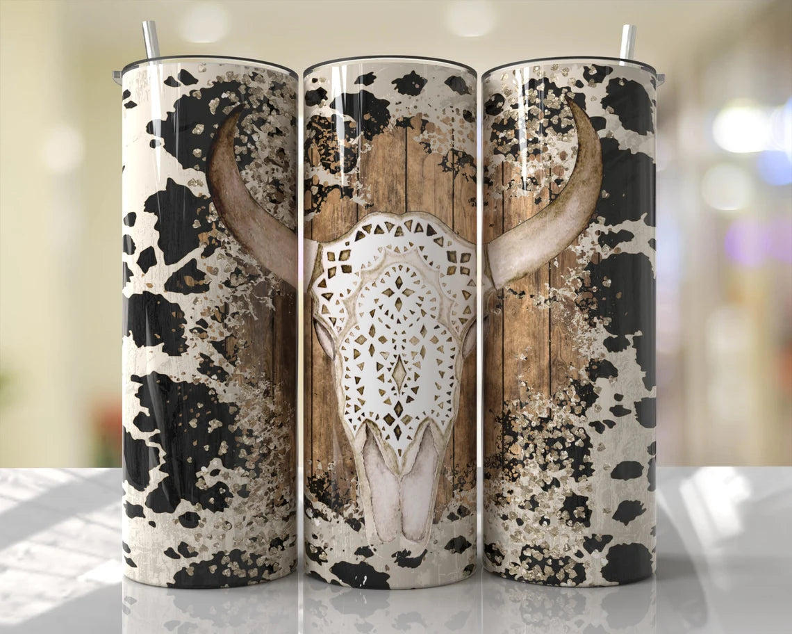 20oz western tumbler featuring a rustic cow skull with cow print, distressed wood, and boho western accents.