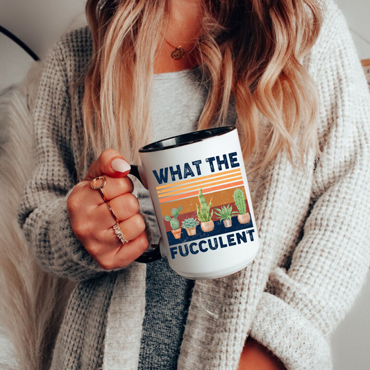 White ceramic coffee mug with black handle featuring a funny "What the Fucculent" graphic with potted succulents, cactus, and retro sunset stripes. Perfect gift for plant lovers and gardeners.