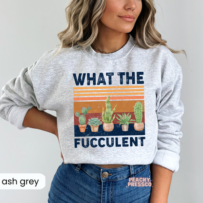 Ash grey crewneck sweatshirt featuring a distressed "What the Fucculent" graphic with colorful succulents, cactus, and vintage sunset stripes. Funny gardening sweatshirt for plant lovers.