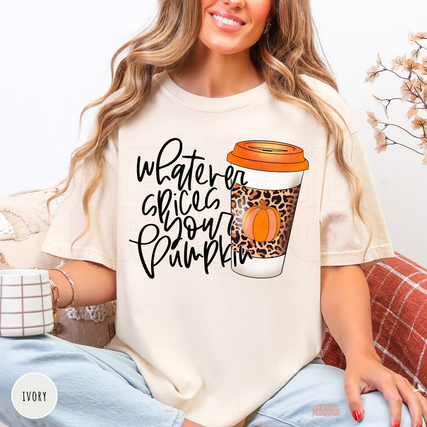 Woman wearing an ivory Comfort Colors t-shirt featuring a "Whatever Spices Your Pumpkin" graphic with a leopard print pumpkin spice coffee cup and orange lid.