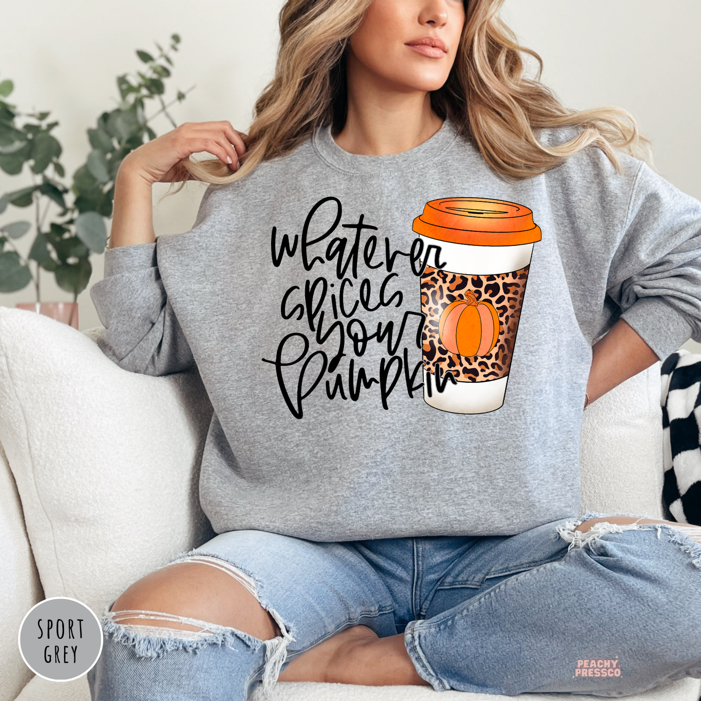 Woman wearing a sport grey crewneck sweatshirt featuring a "Whatever Spices Your Pumpkin" design with a leopard print pumpkin spice coffee cup, perfect for fall and autumn.