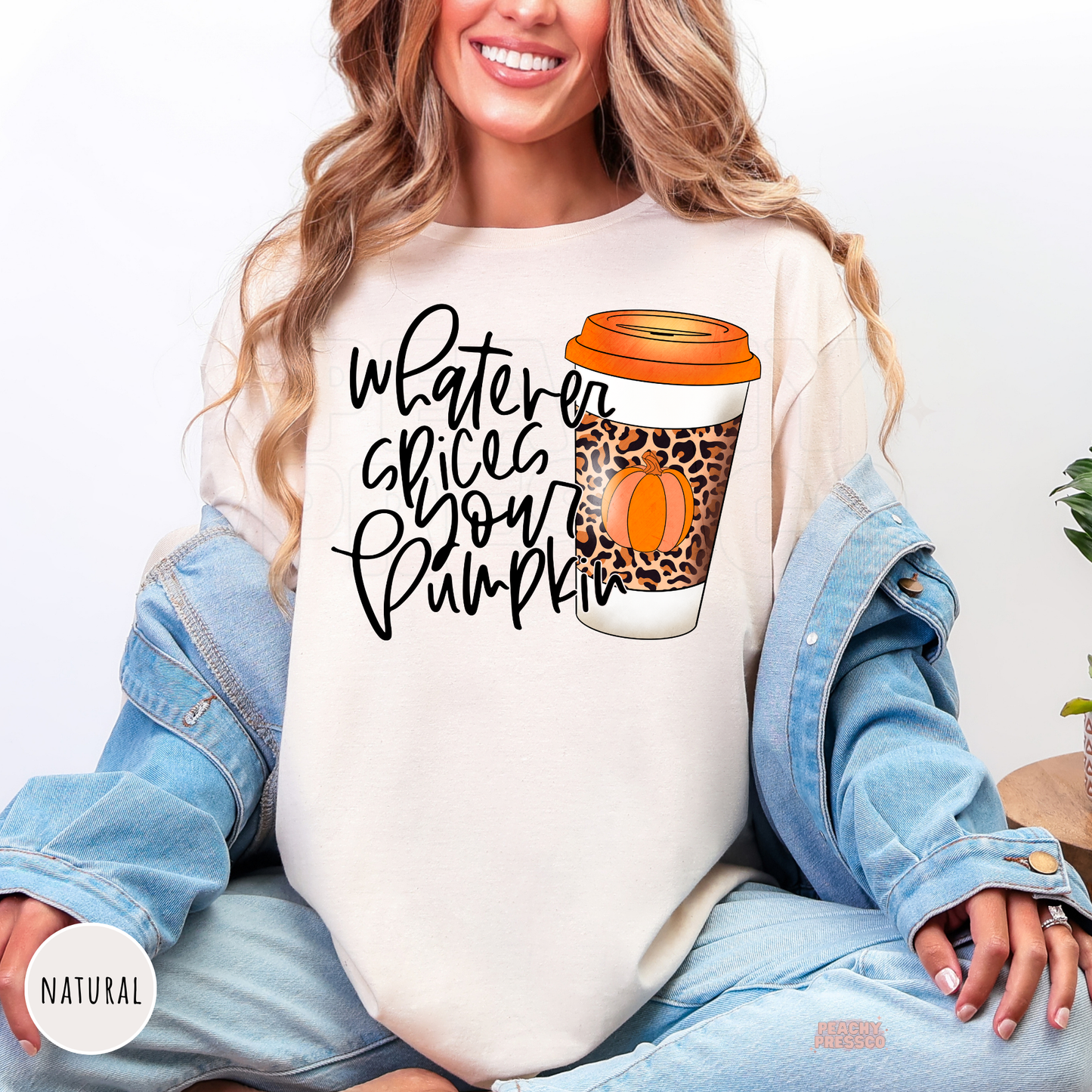 Woman wearing a natural colored t-shirt featuring a "Whatever Spices Your Pumpkin" graphic with a leopard print pumpkin spice coffee cup, cute for autumn, pumpkin season, and coffee lovers.