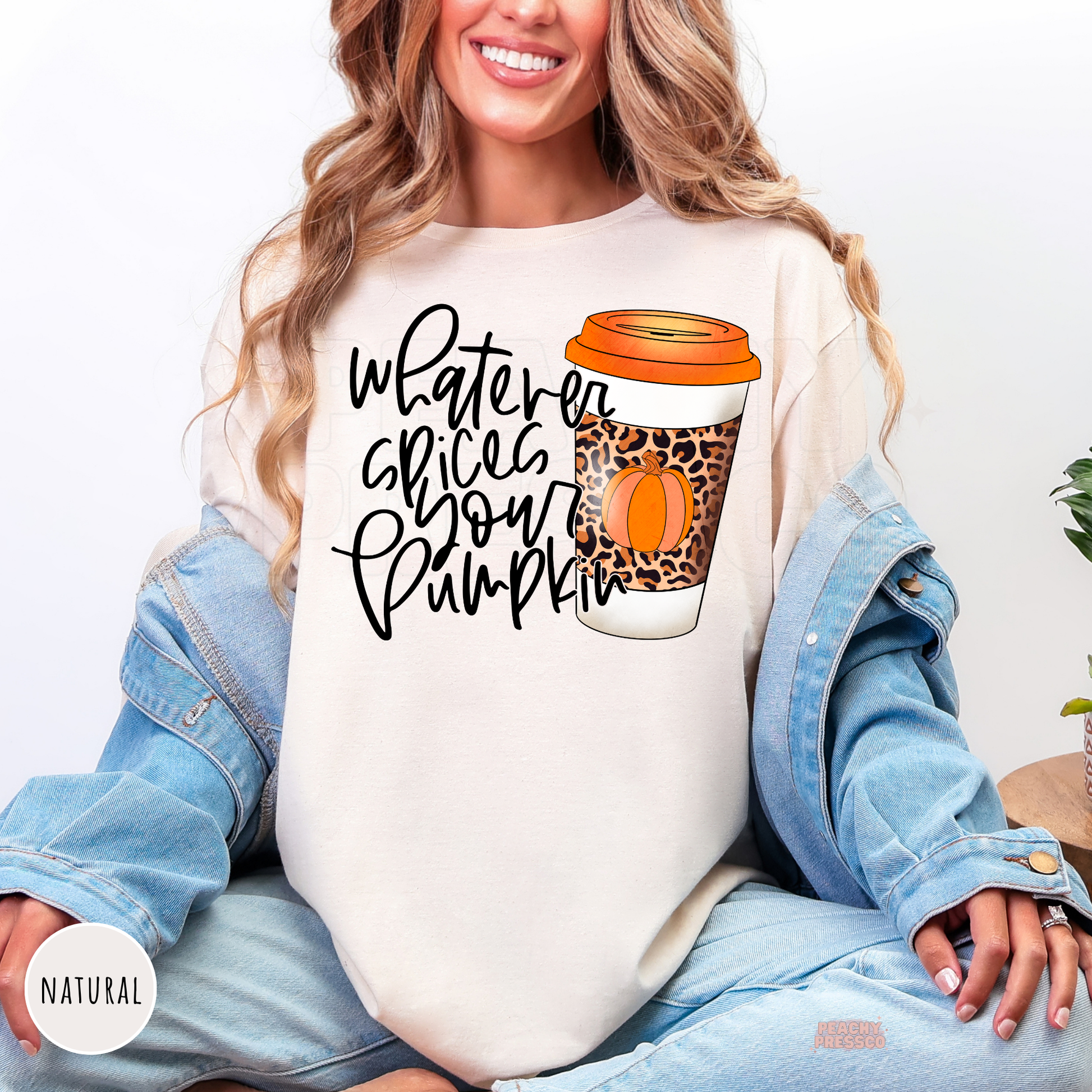 Woman wearing a natural colored t-shirt featuring a "Whatever Spices Your Pumpkin" graphic with a leopard print pumpkin spice coffee cup, cute for autumn, pumpkin season, and coffee lovers.