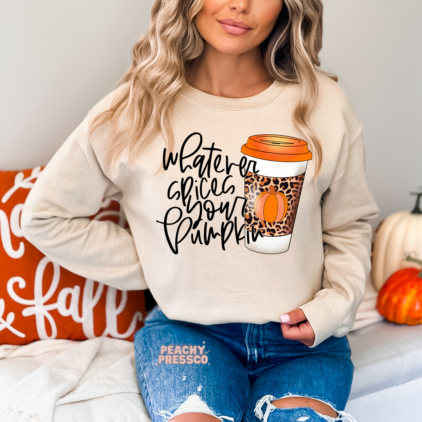 Woman wearing a sand crewneck sweatshirt with a funny "Whatever Spices Your Pumpkin" fall coffee graphic featuring a leopard print pumpkin coffee cup.