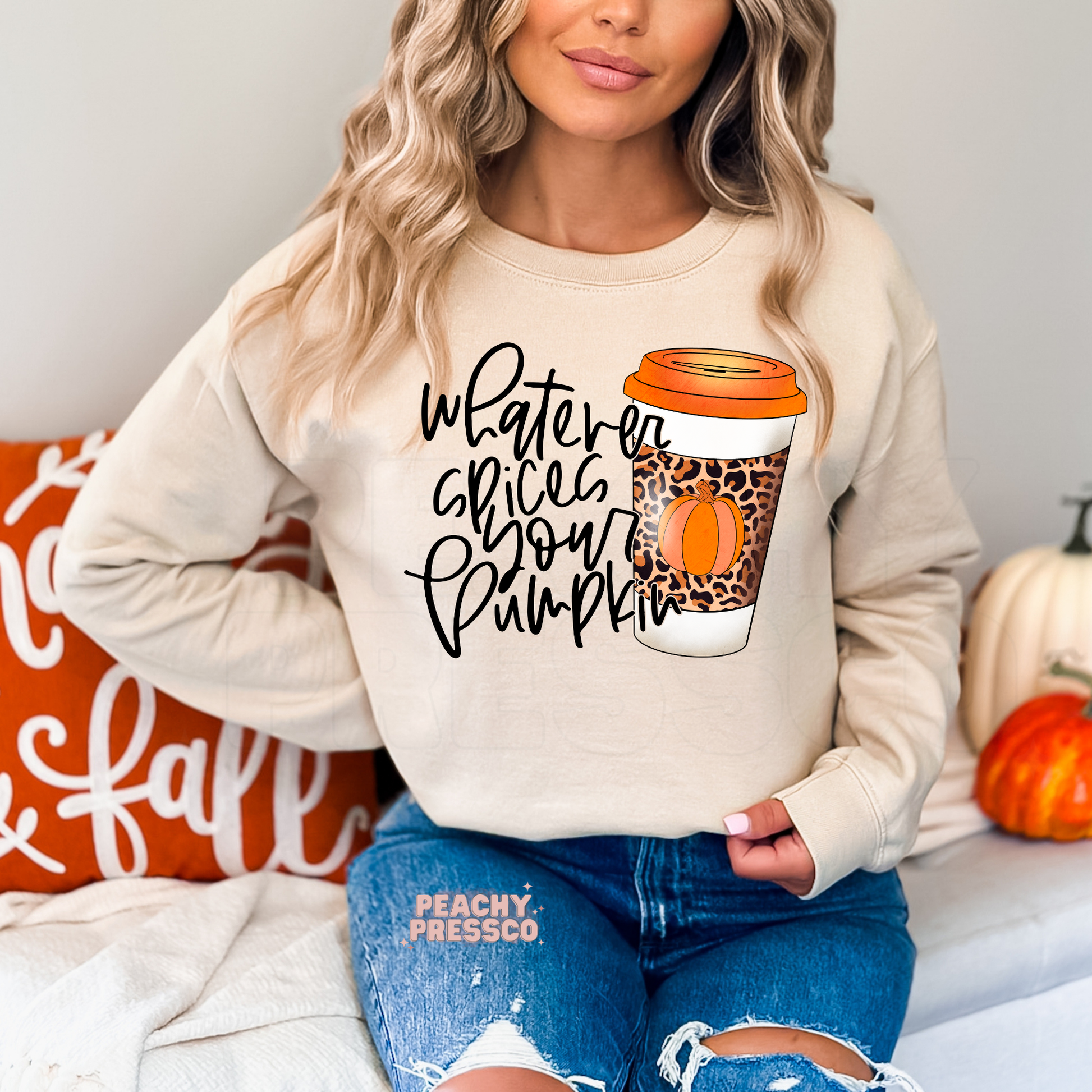 Woman wearing a sand crewneck sweatshirt with a funny "Whatever Spices Your Pumpkin" fall coffee graphic featuring a leopard print pumpkin coffee cup.