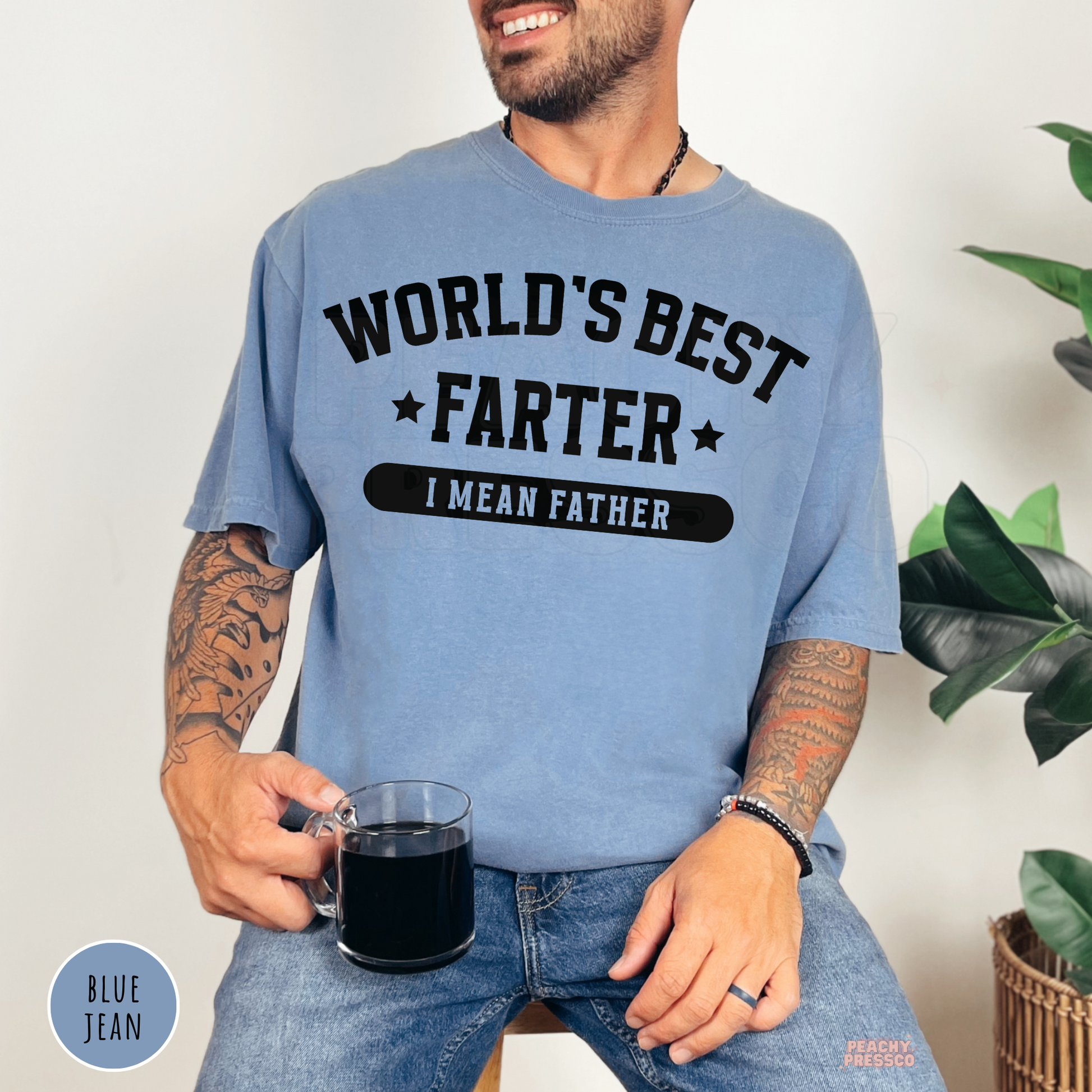 Blue Jean Comfort Colors t-shirt featuring the funny World's Best Farter I Mean Father graphic in bold black lettering, a humorous Father's Day gift for dads.