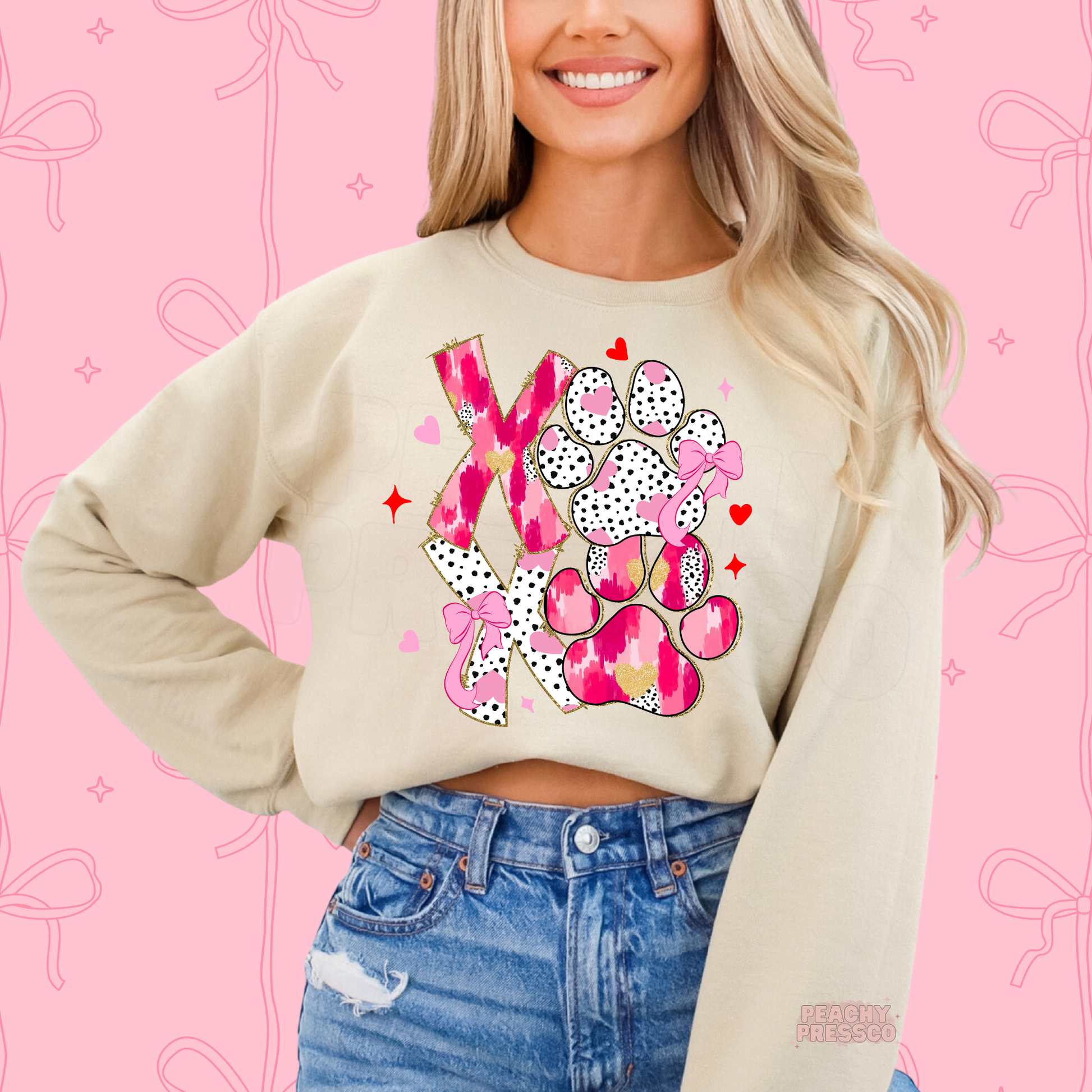 Sand sweatshirt featuring a pink XOXO dog paw graphic with bows, hearts, and playful Valentine's Day accents for dog lovers.
