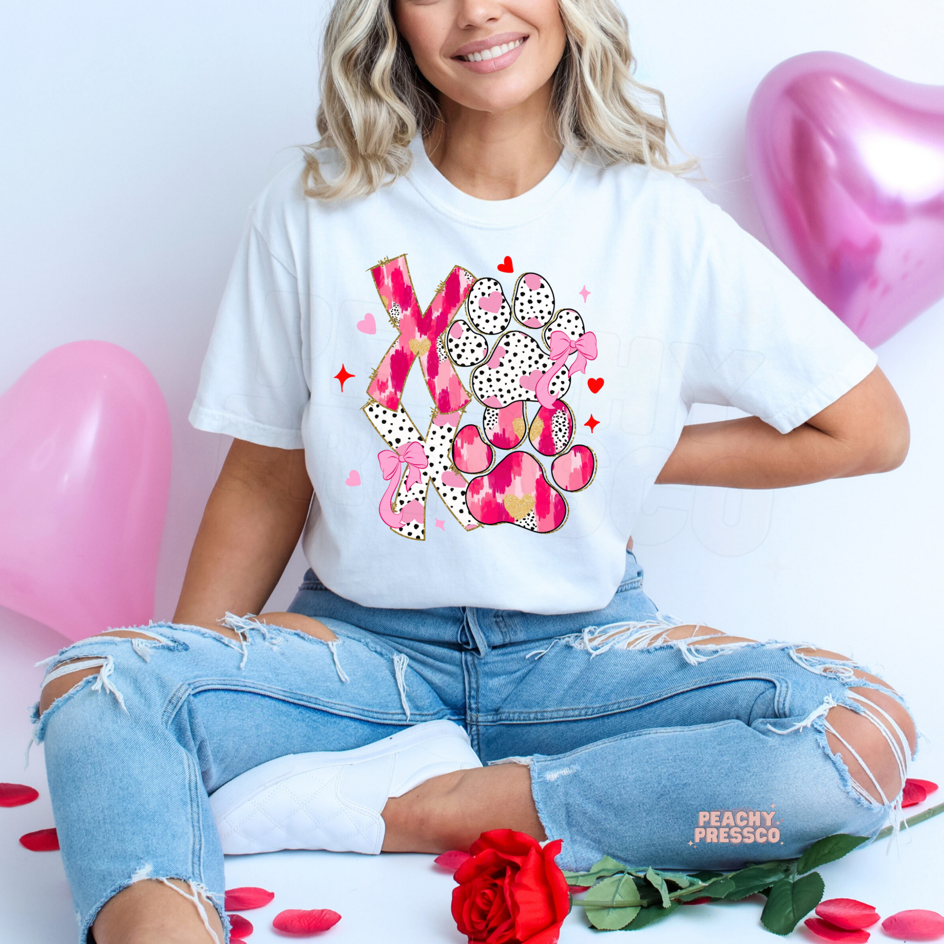 White unisex t-shirt featuring a pink XOXO dog paw print graphic with hearts and bows, a cute Valentine's Day gift for dog lovers.