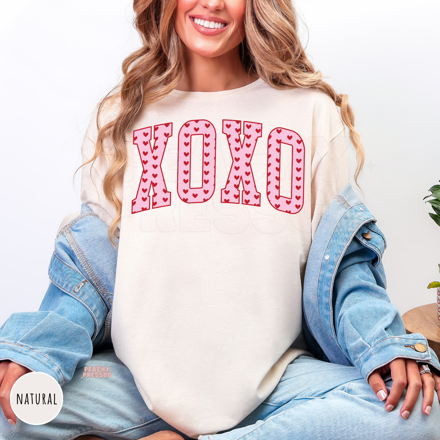 XOXO Valentine's graphic printed on a natural shirt featuring bold varsity letters filled with red hearts for a cute coquette look.
