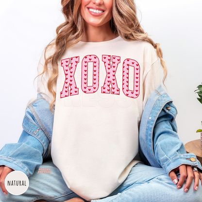XOXO Valentine's graphic printed on a natural shirt featuring bold varsity letters filled with red hearts for a cute coquette look.