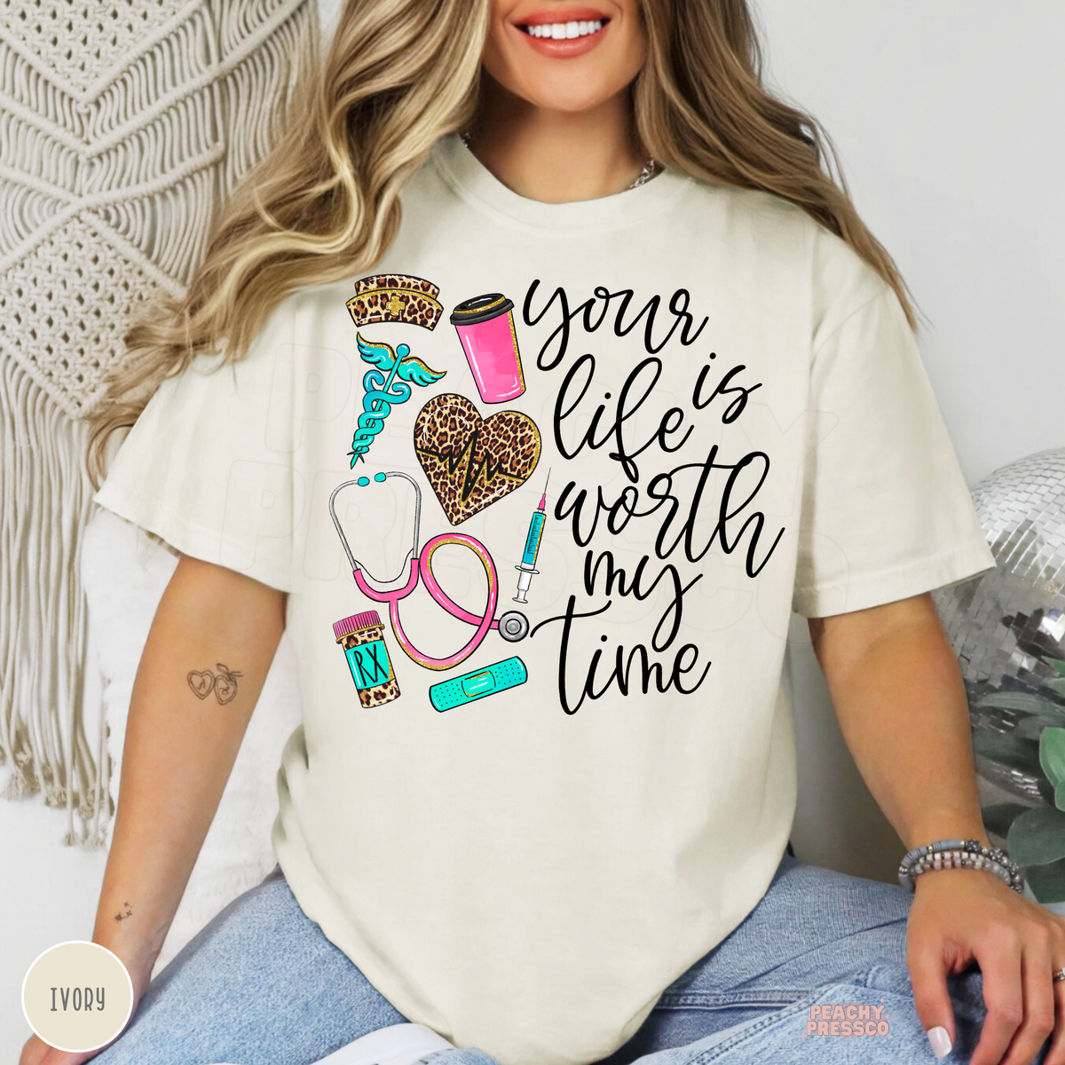Ivory nurse T-shirt with Your Life Is Worth My Time quote, leopard print nursing hat and heart, pink coffee cup, stethoscope and medical icons.