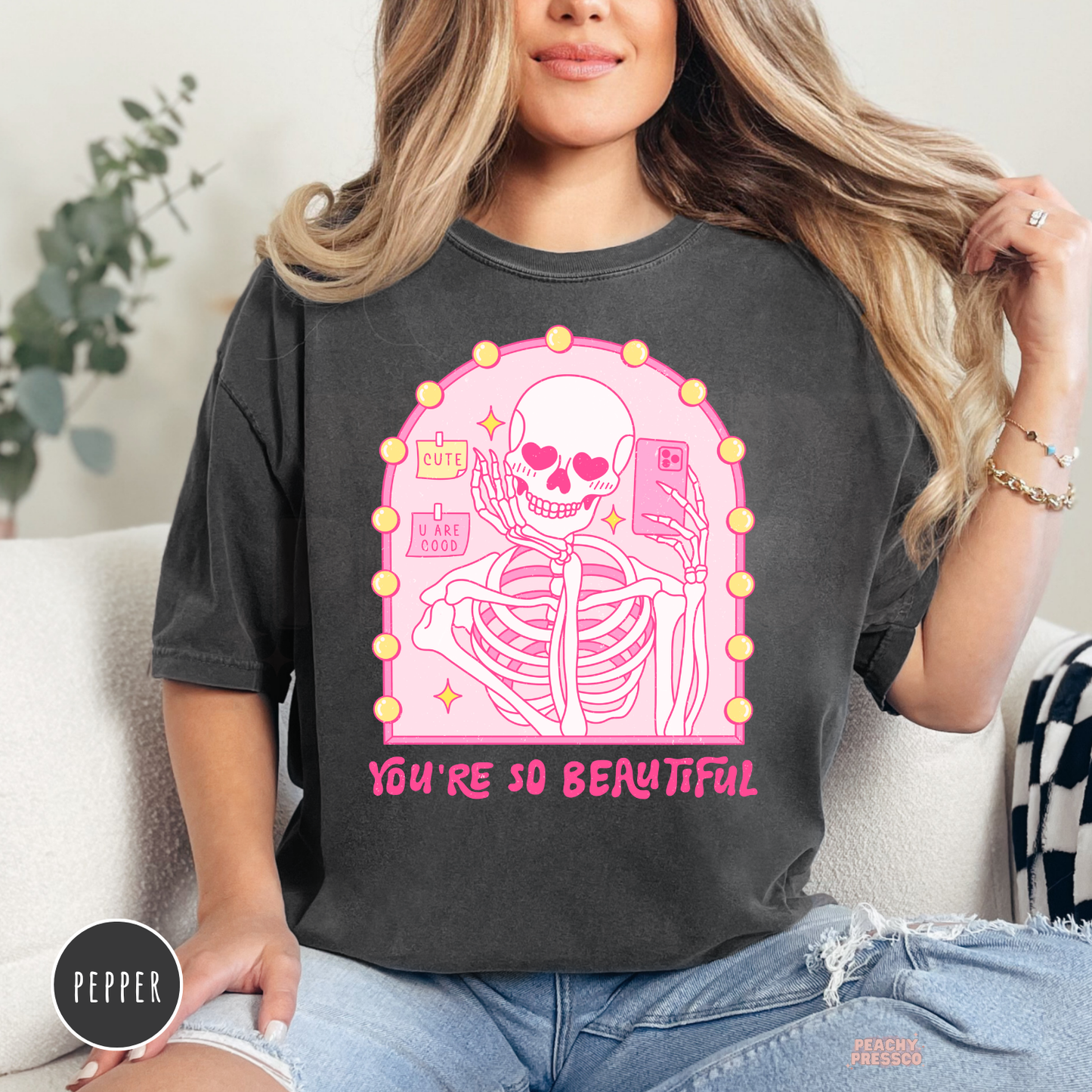 Pepper Comfort Colors t-shirt featuring a pink skeleton taking a mirror selfie with heart eyes and the quote "You're So Beautiful" in a cute coquette Valentine's design.